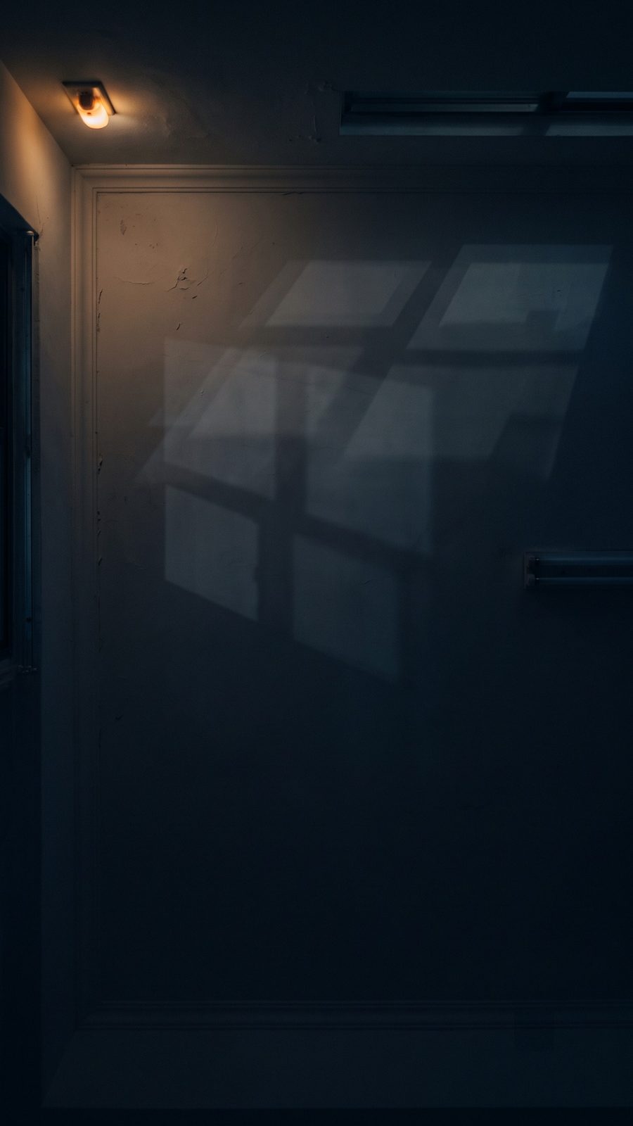 夜裡房間牆面上的窗格光影